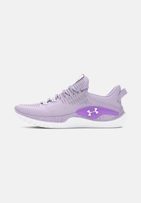 Zapatilla de running Under Armour de color púrpura con suela blanca, área del talón texturizada y cordones sobre un fondo gris liso.