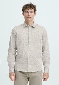 Lys farget skjorte med lange ermer, fin, mørk spraglete mønster, knappestolpe foran og standard krage. Myk stoffstruktur, tilpasset passform.