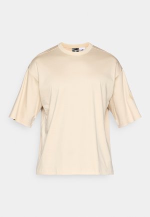 Beige katoenen t-shirt met korte, brede mouwen, een ronde halslijn en een relaxte pasvorm. Glad textuur zonder zichtbare patronen of logo's.