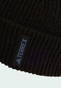Černá pletená čepice s vroubkovanou texturou a plochou černou nášivkou s nápisem "TERREX" ve světle modré barvě. Jednoduchý, ležérní design.