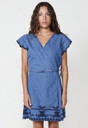 Denim Wickelkleid mit weit geschnittenen Ärmeln, tiefem V-Ausschnitt und marineblauen, gestickten Blumenverzierungen am Saum. Mit einem Bindegürtel.
