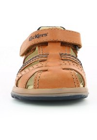 Sandal in pelle arancione con design a intaglio, chiusura con strap in Velcro, accenti neri e suola di colore chiaro. È visibile il nome del marchio "Kickers".