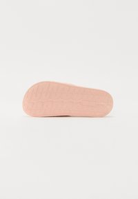 Rosa gummisåle med et teksturert gripe mønster. Rund form med kanaldetaljering og et logo til stede på siden.