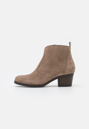Bottine en daim marron avec un talon bloc bas, un bout rond et une languette à l'arrière sur fond blanc uni.