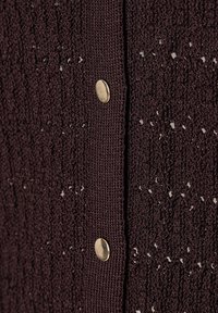 Gebreide cardigan in donker bordeaux met een textuurpatroon, voorzien van kleine metalen knopen en subtiele accenten die het ontwerp verbeteren.