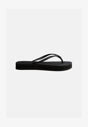 Svart gummikflip-flop med teksturert såle og Y-formet stropp, vist i sideprofil mot en jevn, lys bakgrunn.