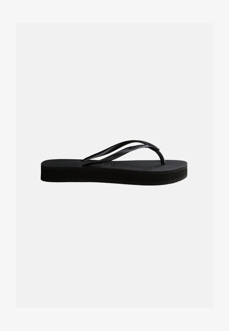 Infradito nero in gomma con suola texturizzata e cinturino a forma di Y, mostrato di profilo su uno sfondo chiaro uniforme.