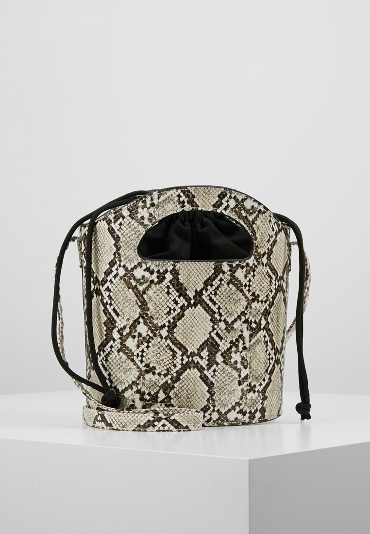 Petit sac style seau avec imprimé serpent beige et marron, fermeture à cordon en tissu noir, et bandoulière assortie à l'imprimé serpent.