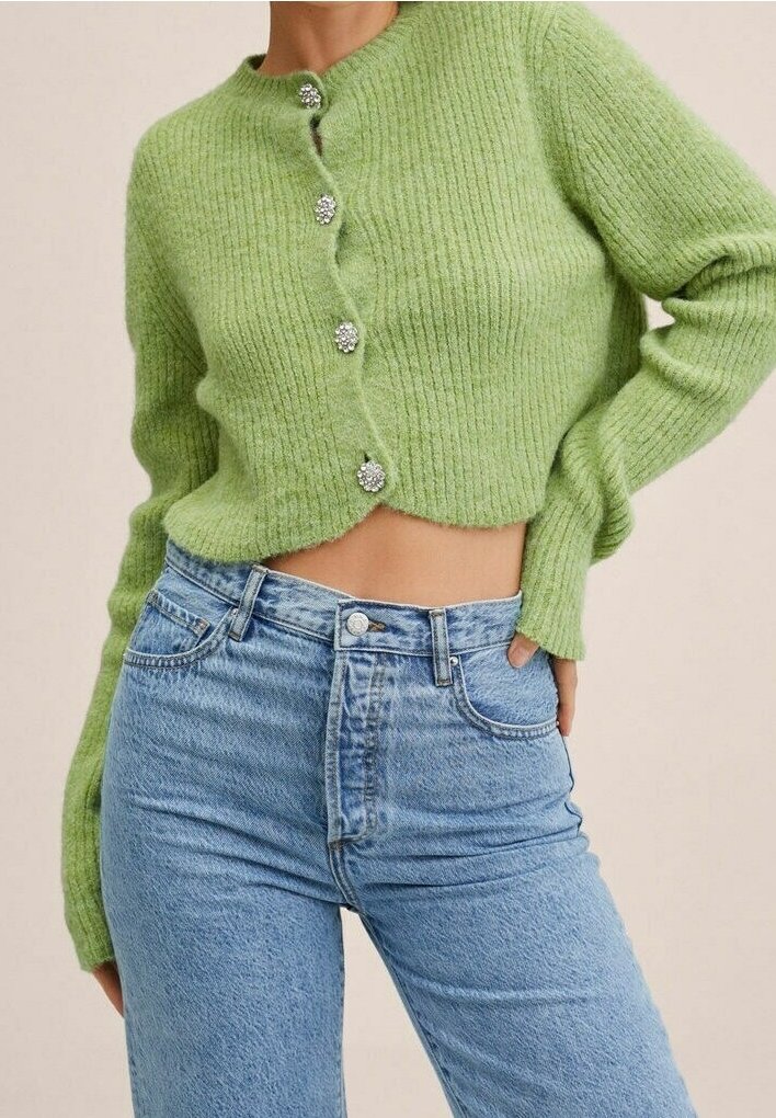Cardigan court vert clair côtelé avec boutons bijoux, associé à un jean denim bleu clair taille haute sur une personne debout.