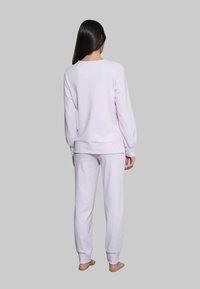 Completo di felpa e pantaloni jogger di colore viola chiaro, con vestibilità sfiancata, maniche lunghe e polsini elasticizzati. Tessuto morbido con dettagli minimi.