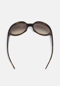 Óculos de sol redondos em tartaruga com lentes castanhas em degradê. Acabamento liso e brilhante; hastes finas e curvadas com discretos detalhes de metal.