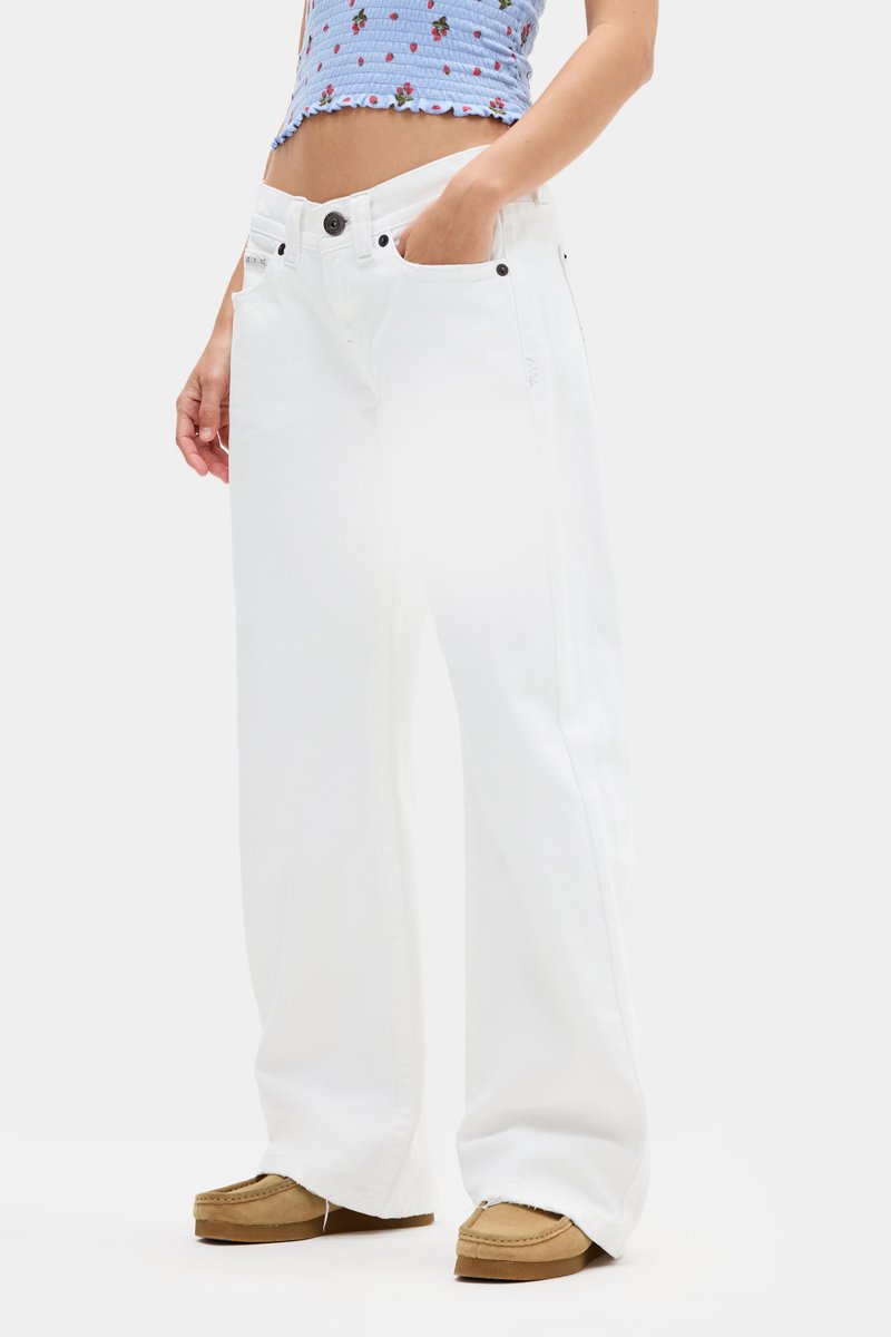 Pantalones vaqueros de pierna ancha blancos con cintura alta, hechos de denim, con bolsillos frontales y herrajes metálicos negros. Textura suave y corte recto.