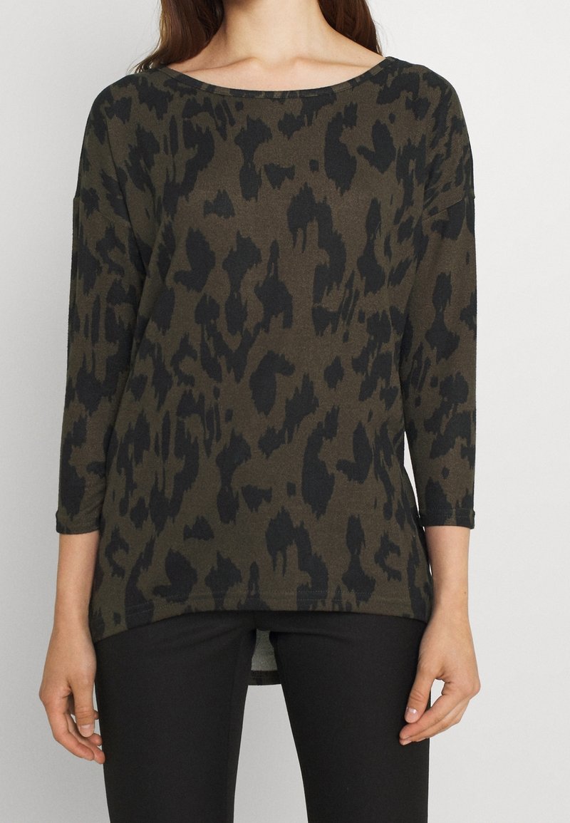 Tunique à manches longues vert foncé avec un motif léopard noir, présentant un large col rond et une coupe décontractée. Tissu doux et texturé.