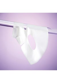 Wit hydrogel gezichtsmasker hangend aan een zilveren staaf tegen een zachte paarse achtergrond.