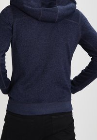 Marineblauwe hoodie met een gestructureerde stof, voorzien van een capuchon met trekkoord, geribbelde manchetten en zoom, met een sportief, casual ontwerp.