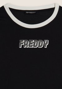 Maglietta nera con collo a girocollo bianco. Presenta la scritta "FREDDY" in grassetto e in caratteri stilizzati bianchi attraverso il petto. Tessuto morbido.