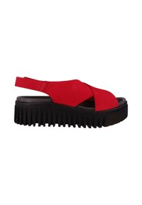 Sandale à talon rouge avec des brides entrecroisées, un dessus texturé et une semelle épaisse en plateau noir nervurée. Design léger et ouvert.
