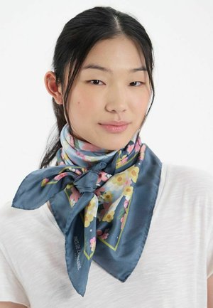 Foulard en soie avec un fond bleu et des motifs floraux en rose et jaune, noué à l'avant pour une forme structurée.