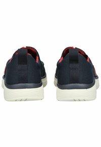 Sneaker in tessuto navy con accenti rossi, design slip-on, materiale testurizzato e suole in gomma bianca con sottili motivi a onda.