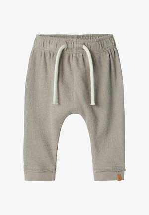 Ljust gråa barnbyxor i sweatshirtmaterial med elastiskt midjeband och vit dragsko. Har ribbade ankelfållar och en liten varumärkeslogotyp på sidan.