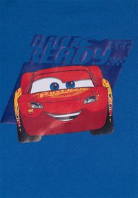 Auto da corsa rossa animata con faccia sorridente e occhi blu, numero 95, su sfondo blu con il testo "Pronto per la corsa".