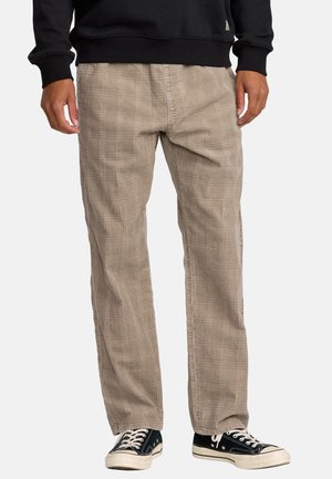Beige plaid relaxed-fit pants with a textured finish, featuring a straight leg design and worn with black canvas sneakers.