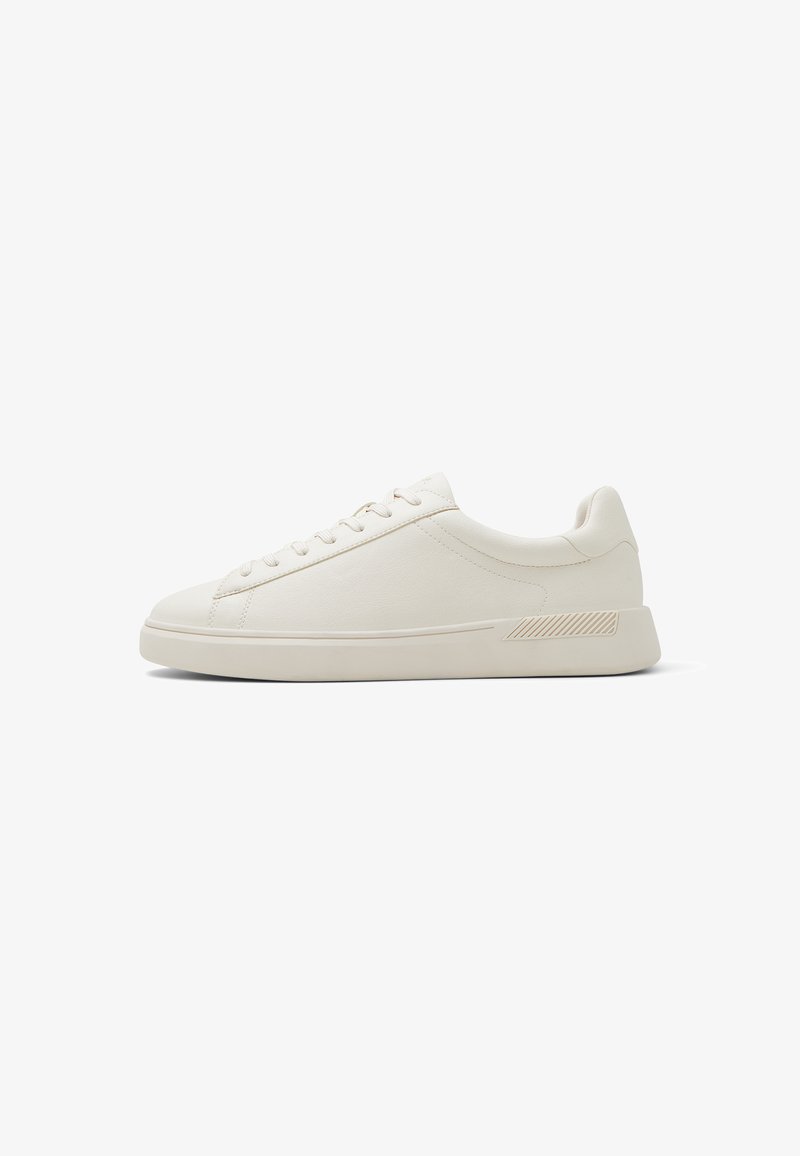Low-profile, off-white leather sneaker with lace-up closure and minimalist design, shown in side view on a white background.