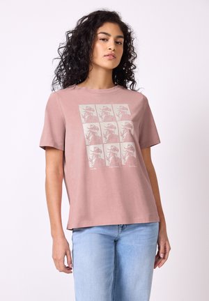 Camiseta de algodón rosa con un estampado gráfico de nueve imágenes de dinosaurios y texto, con un corte relajado y mangas cortas.