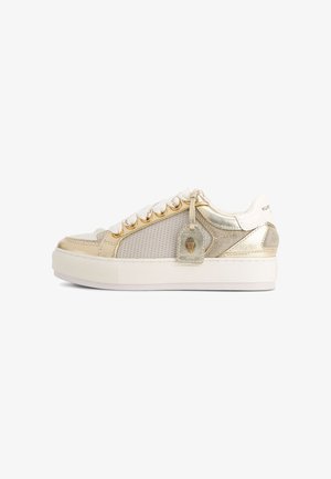 Sneaker low-top con suola bianca, dettagli dorati e beige, pannello laterale in mesh, lacci bianchi e una piccola etichetta appesa vicino ai lacci.