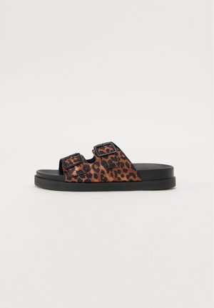 Leopard print sandals with two adjustable black buckles, featuring a flat black sole and soft textured upper material.