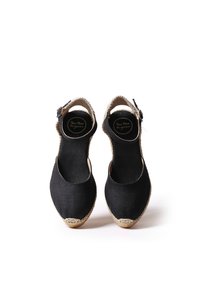 Černé plátěné espadrilky s kulatou špičkou, juteovou podrážkou a páskem kolem kotníku s kovovou sponou, s hladkým povrchem a jednoduchým designem.