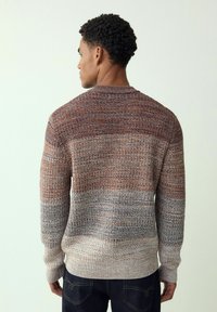 Sweter dziergany z teksturowanym wzorem w ciepłych odcieniach pomarańczy, brązu i niebieskiego, z okrągłym dekoltem i ściągaczami na rękawach.