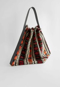 Textiltasche mit gerafftem Oberteil, ausgestattet mit einem bunten geometrischen Muster in Rot, Schwarz und Creme, ergänzt durch einen schwarzen Lederhenkel.