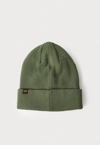 Beanie verde tricotat cu un manșon pliat, având un material texturat și un mic eticheta cu logo negru coasă pe lateral.