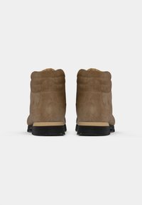 Braune Wildleder-Ankle Boots mit einer strukturierten Oberseite, gepolstertem Kragen und schwarzem Gummisohle. Mit einer kontrastierenden, sandfarbigen Zwischensohle und rundem Zehendesign.
