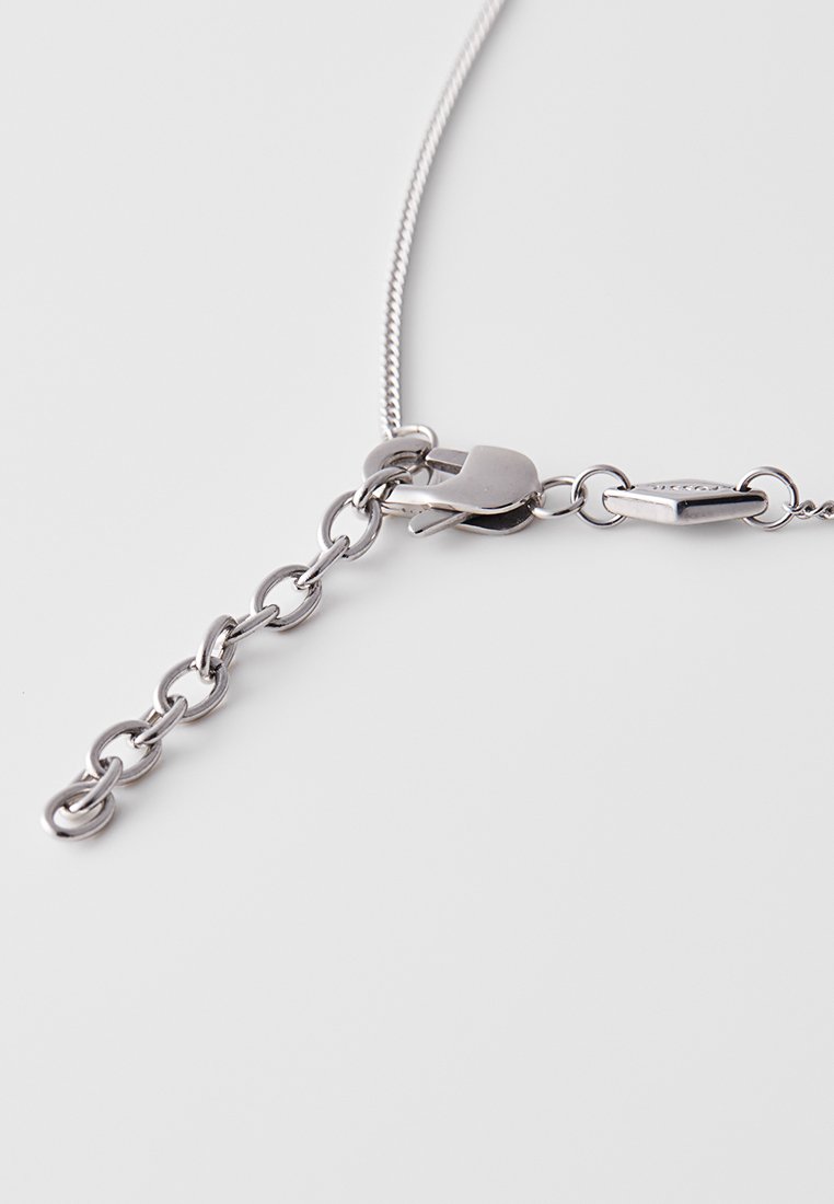 Silberne Kettenhalskette mit flachen Gliedern. Verfügt über einen Verschluss und eine kurze Verlängerungskette. Glatte, metallische Textur.