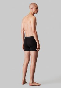 Schwarze Baumwoll-Boxershorts mit einem Bund, der das Calvin Klein-Logo trägt, aus leichtem Stoff und in körpernahem Design.