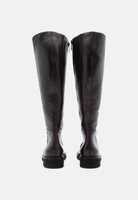 Botas de cuero marrón hasta la rodilla con una superficie suave, que cuentan con un cierre de cremallera lateral y un resistente tacón negro. Diseño sencillo y elegante.