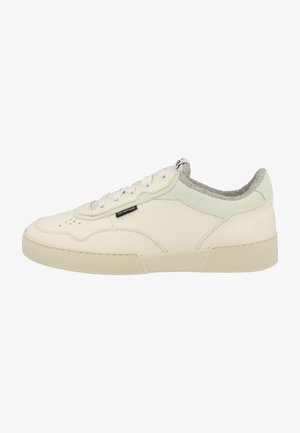 Textured cream leather sneaker with perforated details, gray suede accents at the heel, and a rubber sole. Features white laces and tongue.