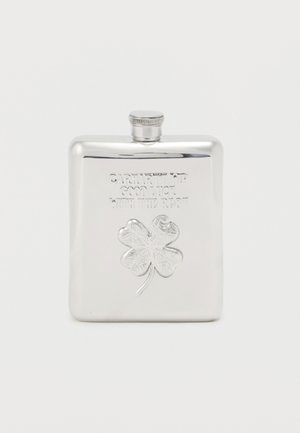 Polished stainless steel flask with embossed four-leaf clover and text "Carhartt WIP Good Luck With The Rest" on front.