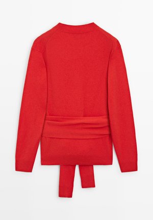 Maglione rosso lavorato a maglia con scollo rotondo, maniche raglan e dettaglio di cintura annodata in vita. Tessuto morbido e polsini e orlo a coste.