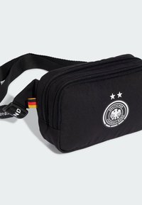 Black fabric crossbody bag with two zippered compartments, featuring a circular logo with an eagle and two stars, adjustable strap.