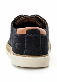 Donkerblauwe suède schoen met een tan leren accent op de hak, uitgerust met een gestructureerde rubberen zool en een minimalistisch ontwerp.