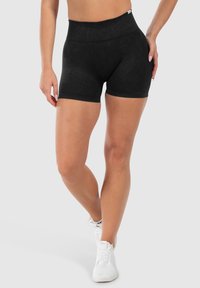 Schwarze, hochgeschnittene Shorts aus weichem, dehnbaren Stoff mit glatter Textur und tailliertem Schnitt, die bis zur Mitte des Oberschenkels reichen.
