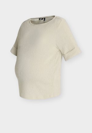 Μπεζ υφασμάτινο τοπ εγκυμοσύνης με κοντά μανίκια που καταλήγουν σε μανσέτες και στρογγυλή λαιμόκοψη, σχεδιασμένο για άνετη εφαρμογή γύρω από την κοιλιά.