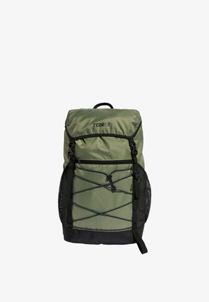 Sac à dos Terrex vert et noir avec rabat supérieur, poche avant zippée, cordons élastiques et poches latérales en mesh sur fond blanc.