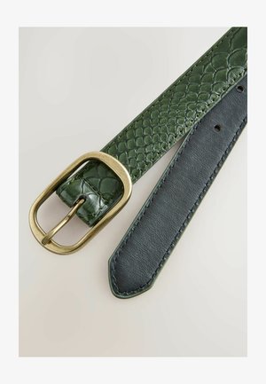 Vihreä kohokuvioitu nahkavyö, jossa on kultatoiminen suorakulmainen solki; sileä musta nahkapuoli; terävä pää ja ompeluyksityiskohdat.