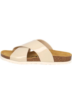 Sandale à glissière en vernis beige avec un pied en liège, un design à bandes croisées et une semelle blanche striée pour une traction supplémentaire.