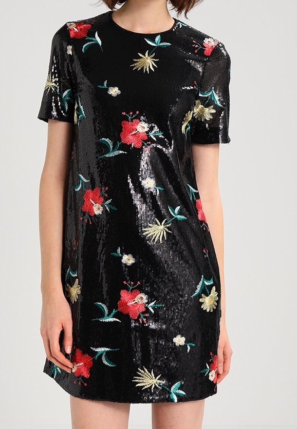Robe noire à manches courtes avec une finition brillante en sequins, décorée de motifs floraux brodés rouges, jaunes, blancs et verts.