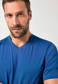 Męski T-shirt z dekoltem w serek w jednolitym niebieskim kolorze, wykonany z gładkiej tkaniny, z krótkimi rękawami i luźnym krojem, z delikatną teksturą.